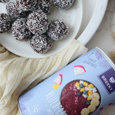 Blissballs mit Kokosraspeln auf weißem Teller