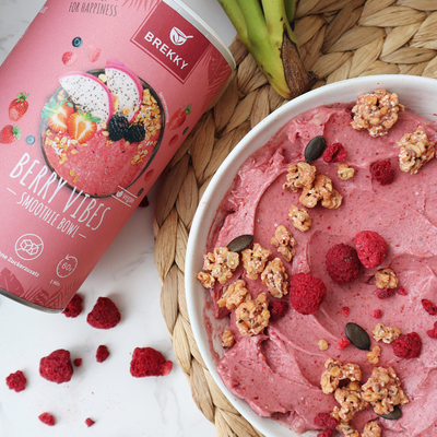 Rosa Nice Cream mit Granola und Himbeeren in Schale