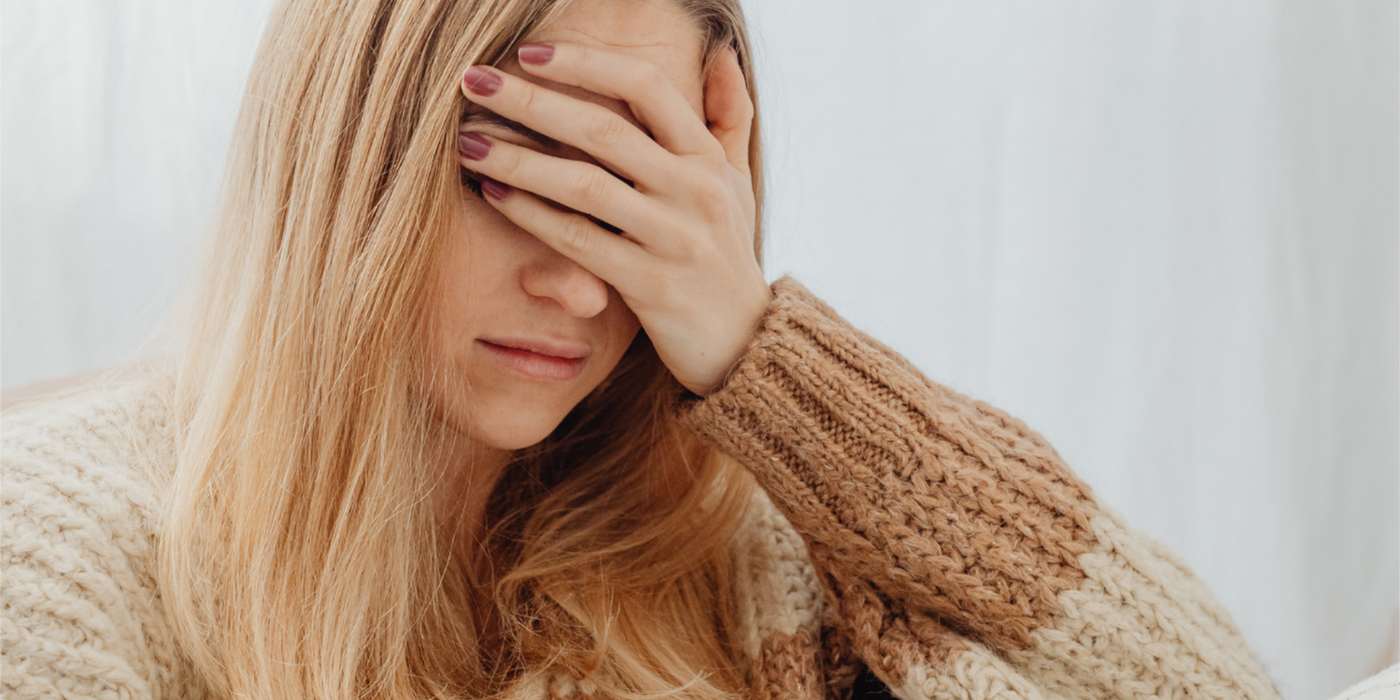 Frau hält sich müde die Hand vor die Augen