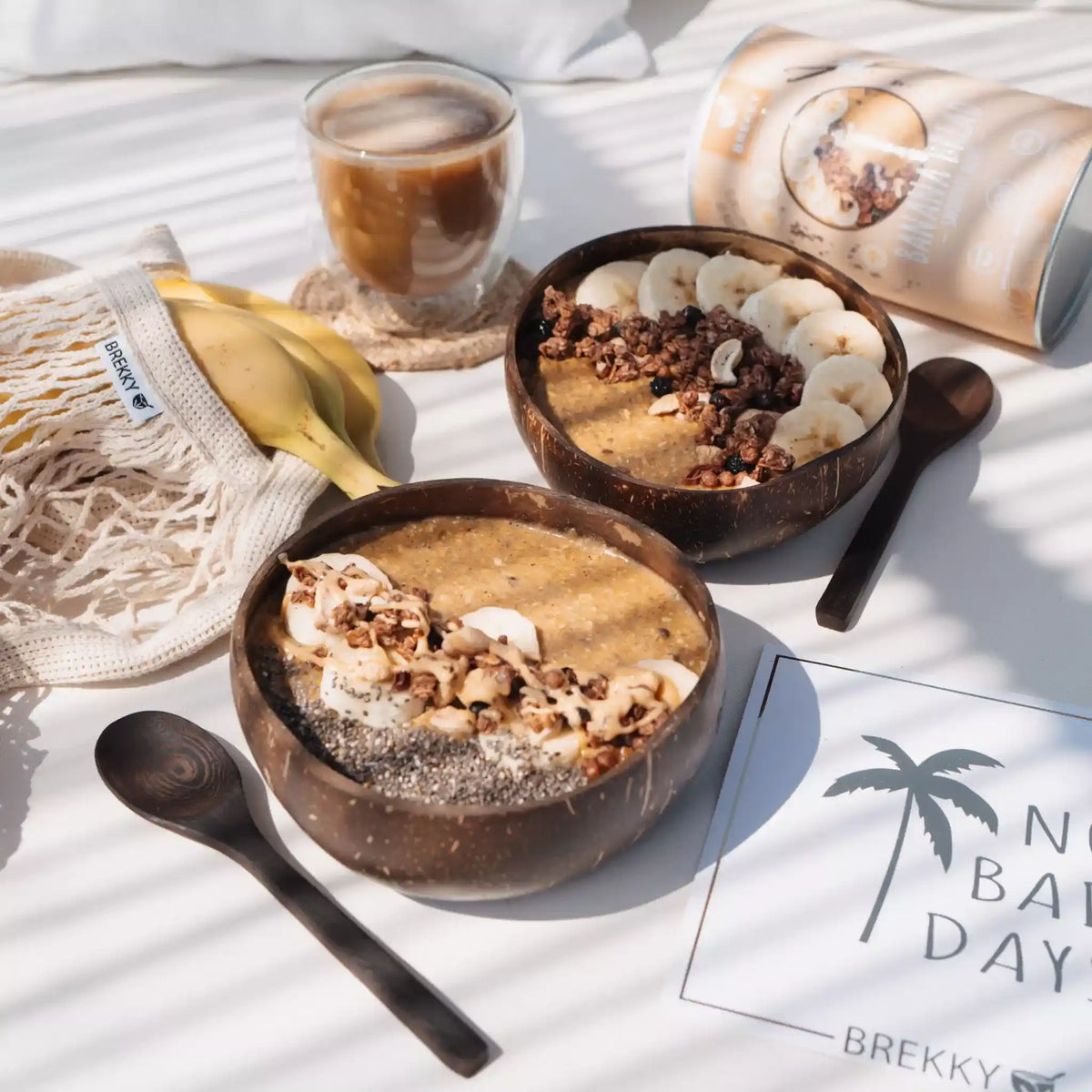Zwei Smoothie Bowls in Kokosnussschalen mit Eiskaffee