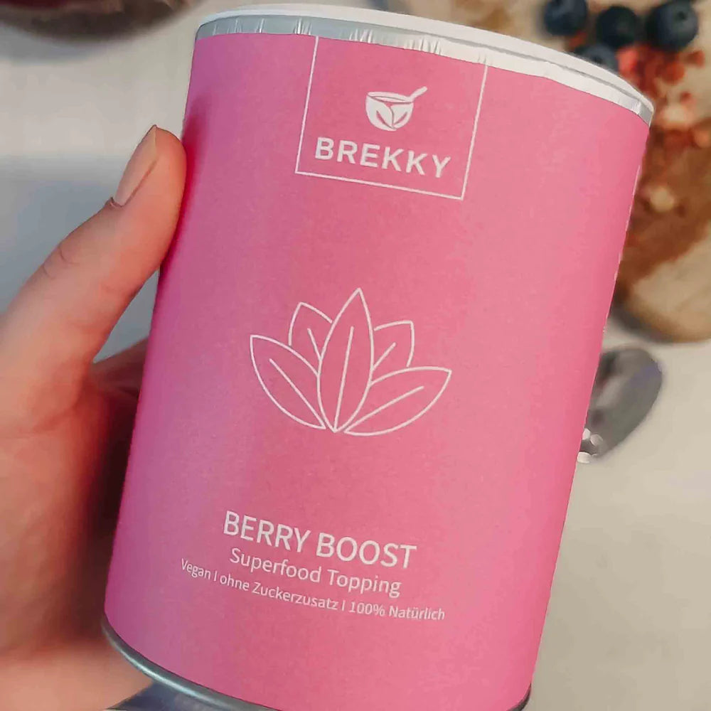 Hand hält Dose Berry Boost Superfood Topping
