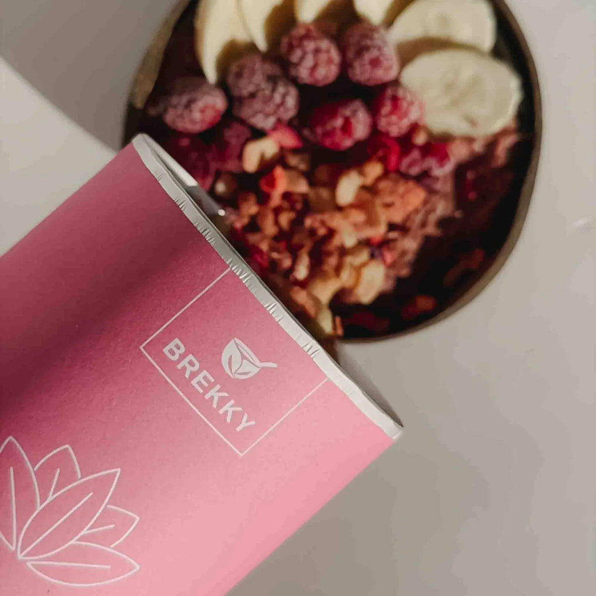 Rosa Verpackung vor Bowl mit Himbeeren