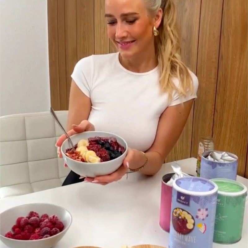 Frau mit Beeren Smoothie Bowl am Tisch